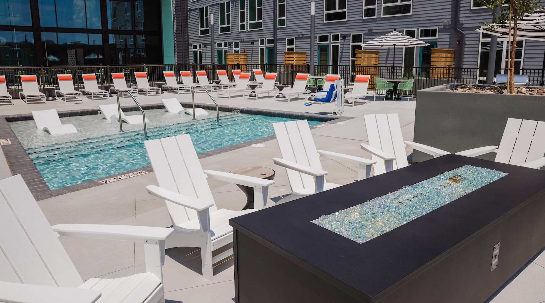 Large sparkling blue pool with a large pool deck and lounge chairs